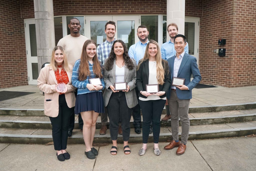 Deonta Woods, Jaazaniah Catterall, Josh Cox, J Hallen, Megan Kahane, Isabel Rose, Kate Shurtleff, Kate Giduz, and Holning Lau pose with their plaques after being honored at the 2022 Pro Bono Publico Awards.