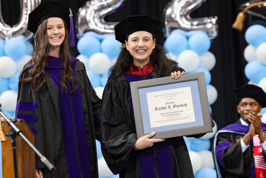 Hannah Long 3L awards Rachel Gurvich the McCall Award for Teaching Excellence at the 2022 UNC Law Commencement.
