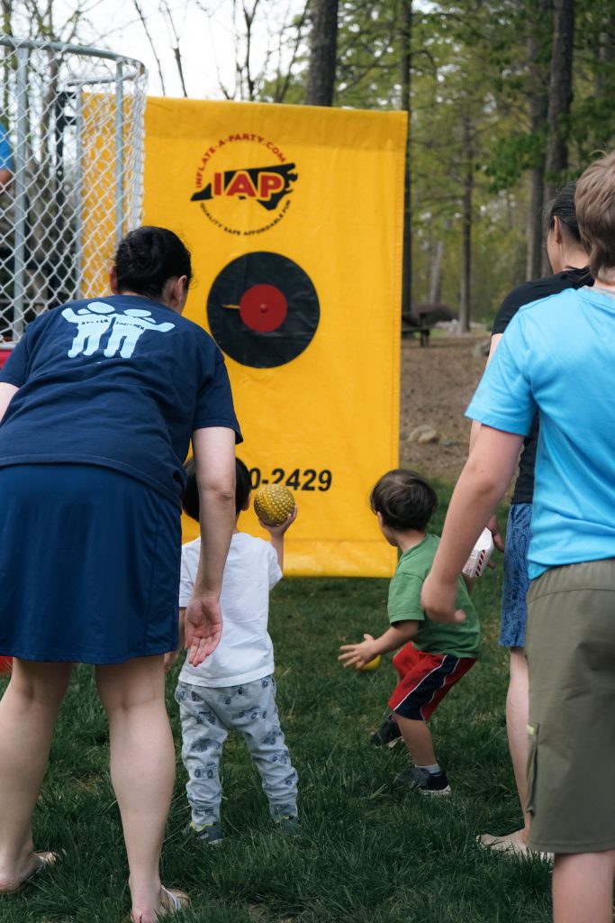 Children of faculty, staff and students try to throw a ball at the dunk tank.