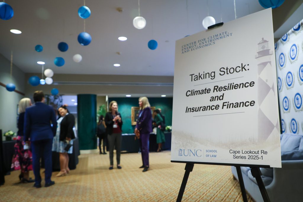 people at meeting with sign of event name